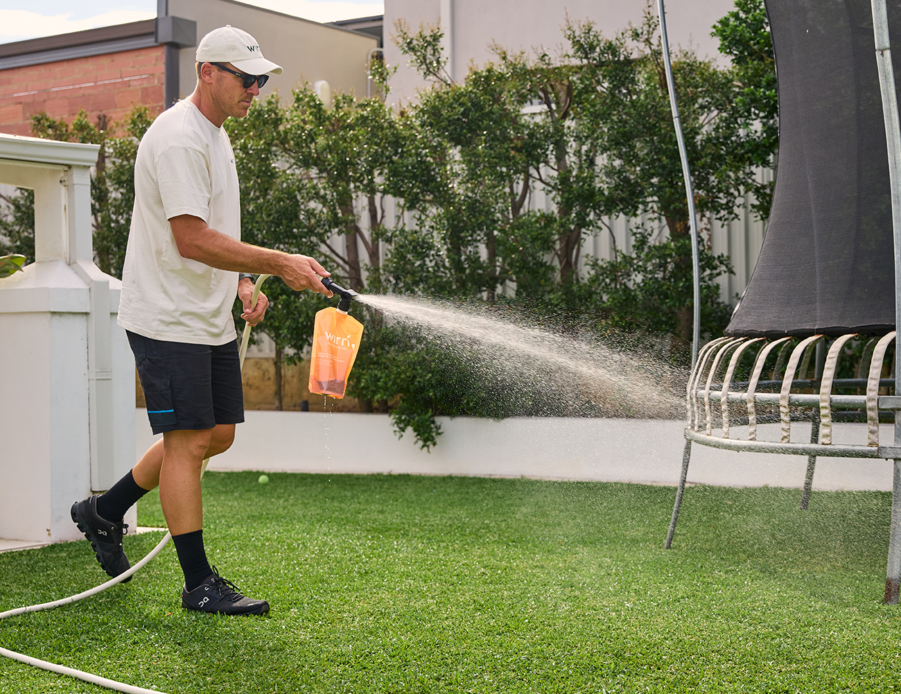 Lawn Care - A man watering a healthy and lush lawn