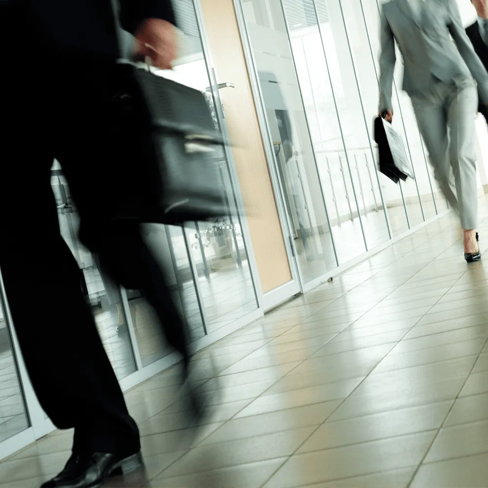 In-the-Trenches-podcast-People-walking-quickly-in-a-corporate-hallway